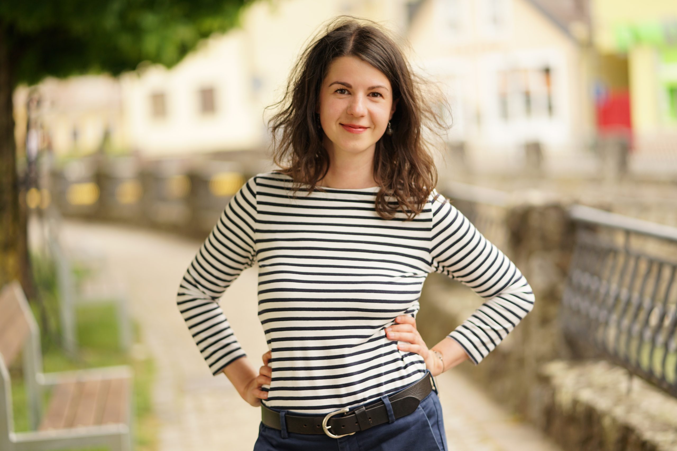 Ivana Bednárová, ikigai koučka, v historickom meste stojaca s rukami v bok a pozitívne naladená